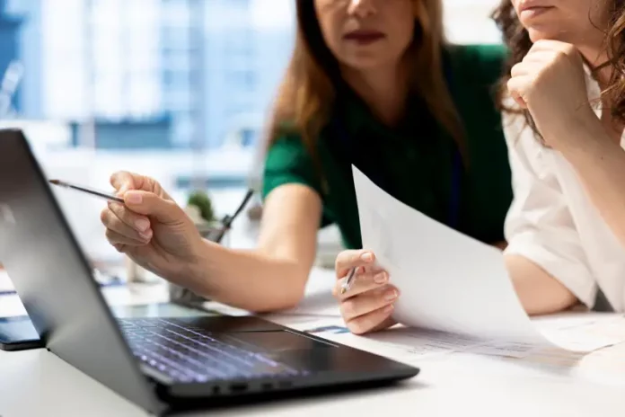 Empresárias analisando planilhas financeiras em laptop, planejando decisões estratégicas para o sucesso de novos negócios