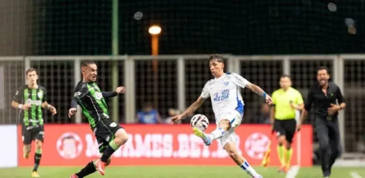 Jogadores do Avaí e América-MG disputando a bola em lance de drible durante partida, em jogo marcado pela crise e dificuldades do Avaí.