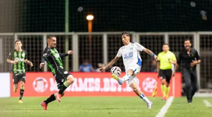 Crise no Avaí: salários atrasados e resultados preocupam torcida Jogadores do Avaí e América-MG disputando a bola em lance de drible durante partida, em jogo marcado pela crise e dificuldades do Avaí.