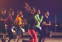 Pessoas correndo à noite em uma corrida de rua, representando a Ibagy 55 Anos Night Run em Florianópolis.