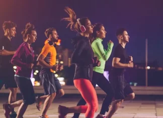 Pessoas correndo à noite em uma corrida de rua, representando a Ibagy 55 Anos Night Run em Florianópolis.