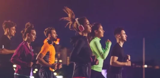 Pessoas correndo à noite em uma corrida de rua, representando a Ibagy 55 Anos Night Run em Florianópolis.