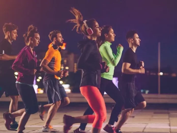 Pessoas correndo à noite em uma corrida de rua, representando a Ibagy 55 Anos Night Run em Florianópolis.