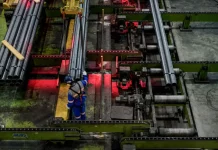 Trabalhador opera linha de produção em indústria metalúrgica de Santa Catarina, representando o crescimento econômico do estado em 2025