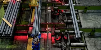 Trabalhador opera linha de produção em indústria metalúrgica de Santa Catarina, representando o crescimento econômico do estado em 2025