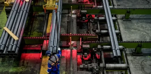 Trabalhador opera linha de produção em indústria metalúrgica de Santa Catarina, representando o crescimento econômico do estado em 2025