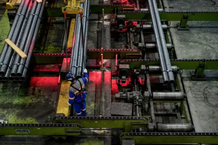 Trabalhador opera linha de produção em indústria metalúrgica de Santa Catarina, representando o crescimento econômico do estado em 2025