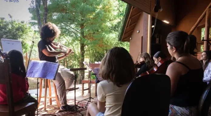 Festival multicultural na Guarda do Embaú oferece oficinas gratuitas e conecta crianças à arte Crianças aprendendo a tocar violino durante oficina do Festival Multicultural na Guarda do Embaú.