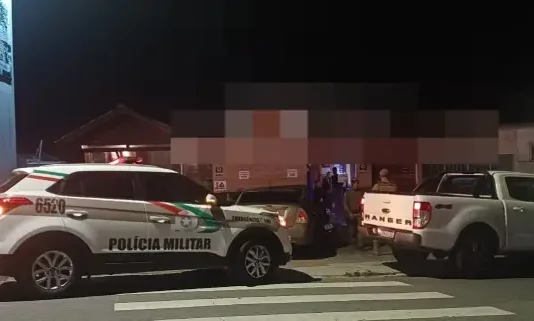 Agentes da Polícia Militar posicionados em frente a um estabelecimento durante a Operação Sossego em São José.