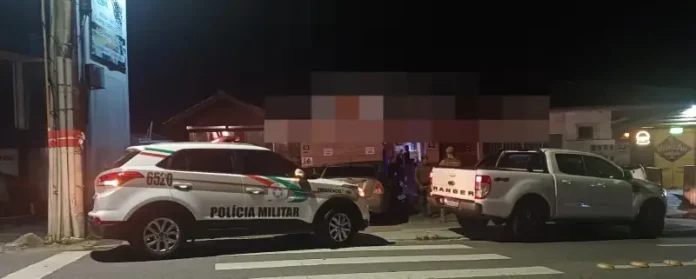 Agentes da Polícia Militar posicionados em frente a um estabelecimento durante a Operação Sossego em São José.