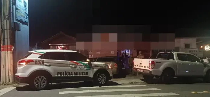 Agentes da Polícia Militar posicionados em frente a um estabelecimento durante a Operação Sossego em São José.