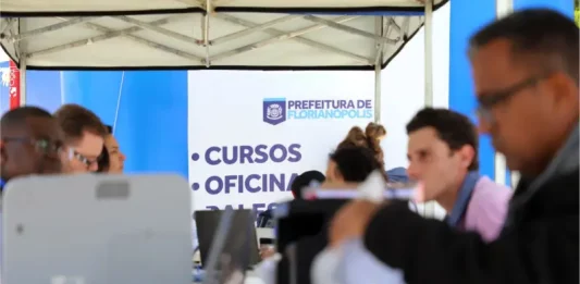 Stands da Prefeitura de Florianópolis em local de atendimento ao público, oferecendo vagas e orientações do programa Floripa Mais Empregos.