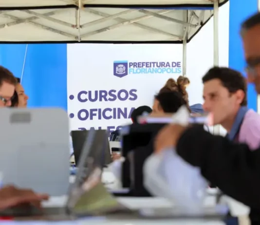Stands da Prefeitura de Florianópolis em local de atendimento ao público, oferecendo vagas e orientações do programa Floripa Mais Empregos.
