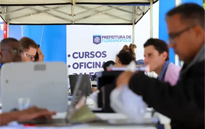 Stands da Prefeitura de Florianópolis em local de atendimento ao público, oferecendo vagas e orientações do programa Floripa Mais Empregos.