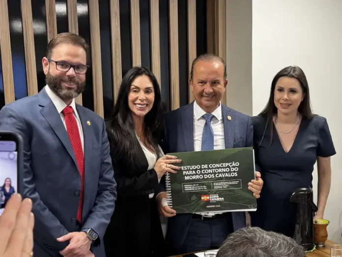 Governador de Santa Catarina, acompanhado da comitiva catarinense, segura em mãos o Estudo de Concepção para o contorno do Morro dos Cavalos, durante apresentação oficial em Brasília.