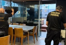 Policiais federais revistam imóvel durante operação contra tráfico internacional de pessoas.