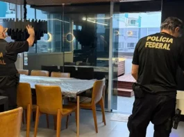 Policiais federais revistam imóvel durante operação contra tráfico internacional de pessoas.