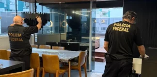 Policiais federais revistam imóvel durante operação contra tráfico internacional de pessoas.