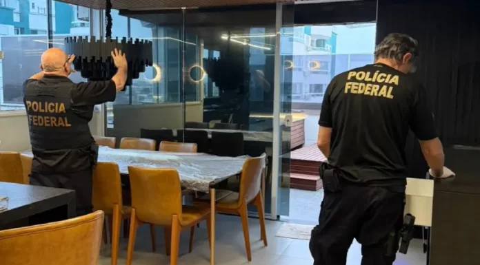Policiais federais revistam imóvel durante operação contra tráfico internacional de pessoas.