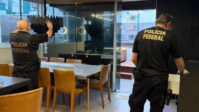 Policiais federais revistam imóvel durante operação contra tráfico internacional de pessoas.