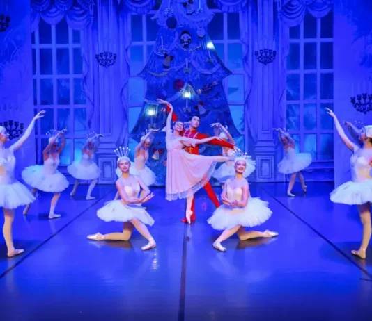 Bailarinos se apresentam no palco durante a encenação da peça O Quebra-Nozes, com figurinos coloridos e movimentos sincronizados que retratam a magia do balé natalino.