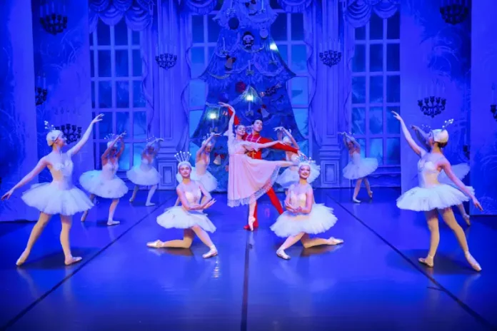 Bailarinos se apresentam no palco durante a encenação da peça O Quebra-Nozes, com figurinos coloridos e movimentos sincronizados que retratam a magia do balé natalino.