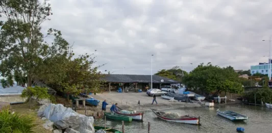 São José abre chamamento público para vagas no Rancho de Pesca Hilário Vieira Barcos de pesca atracados próximos ao Rancho de Pesca Hilário Vieira, na Beira-Mar de São José, com pescadores trabalhando nas redes.