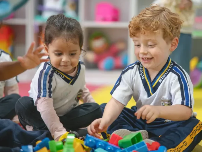 Crianças da Educação Infantil brincam e interagem em sala de aula.
