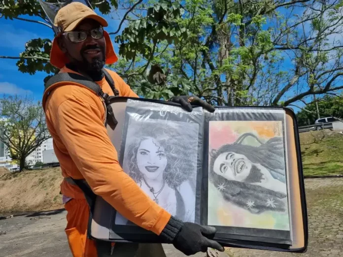 Luciano do Carmo de Paula, roçador de São José, com uniforme de trabalho, segurando uma pasta com seus desenhos artísticos.