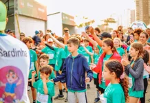 Crianças participam animadas, vestindo camisetas verdes e interagindo em grupo, representando a SouBio Run Kids, em Florianópolis, evento do Dia das Crianças.