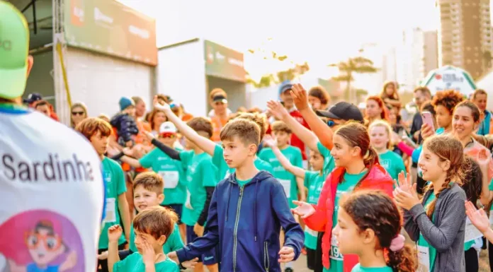 Crianças participam animadas, vestindo camisetas verdes e interagindo em grupo, representando a SouBio Run Kids, em Florianópolis, evento do Dia das Crianças.