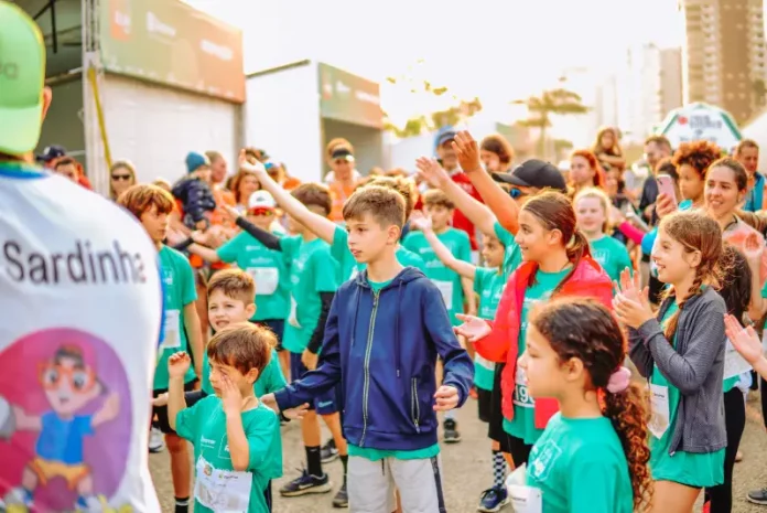 Crianças participam animadas, vestindo camisetas verdes e interagindo em grupo, representando a SouBio Run Kids, em Florianópolis, evento do Dia das Crianças.