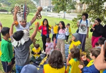 Estudantes e comunidade indígena compartilham um piquenique na agrofloresta, fortalecendo a troca de saberes tradicionais e práticas sustentáveis.