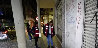Agentes da Prefeitura de Florianópolis, com colete laranja, abordam pessoas em situação de rua para avaliação e possível encaminhamento a internações involuntárias.