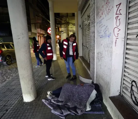 Agentes da Prefeitura de Florianópolis, com colete laranja, abordam pessoas em situação de rua para avaliação e possível encaminhamento a internações involuntárias.
