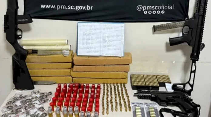 Armas e drogas apreendidas durante operação da Polícia Militar no Norte da Ilha, incluindo espingardas, munições e pacotes de substâncias entorpecentes.