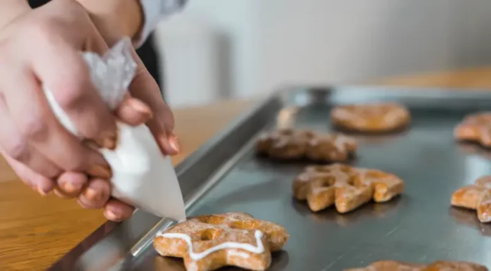 Biguaçu abre inscrições para curso gratuito de fabricação de biscoitos em parceria com o SENAI Mãos de uma mulher confeitando biscoitos, ilustrando o curso gratuito de fabricação de biscoitos oferecido pela Prefeitura de Biguaçu em parceria com o SENAI.