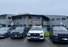 Quatro carros de luxo apreendidos na Operação Falso Samaritano estão estacionados em frente à delegacia de polícia