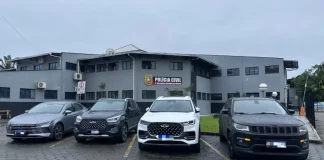 Quatro carros de luxo apreendidos na Operação Falso Samaritano estão estacionados em frente à delegacia de polícia