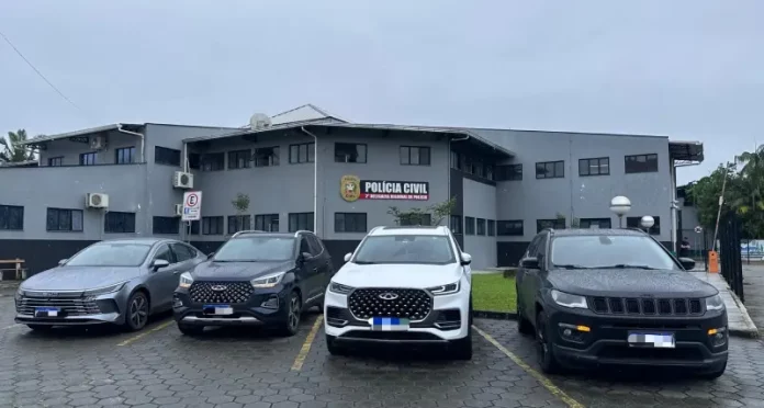 Quatro carros de luxo apreendidos na Operação Falso Samaritano estão estacionados em frente à delegacia de polícia