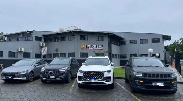 Quatro carros de luxo apreendidos na Operação Falso Samaritano estão estacionados em frente à delegacia de polícia