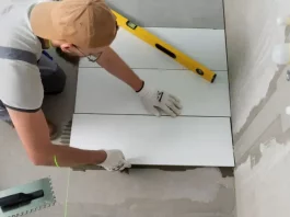 Profissional aplicando piso em obra, representando a qualificação profissional oferecida nos cursos gratuitos de São José.