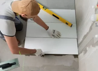 Profissional aplicando piso em obra, representando a qualificação profissional oferecida nos cursos gratuitos de São José.