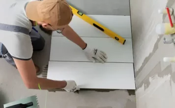 Profissional aplicando piso em obra, representando a qualificação profissional oferecida nos cursos gratuitos de São José.