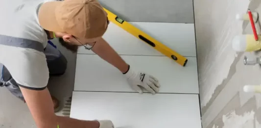 Profissional aplicando piso em obra, representando a qualificação profissional oferecida nos cursos gratuitos de São José.