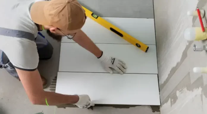 Profissional aplicando piso em obra, representando a qualificação profissional oferecida nos cursos gratuitos de São José.