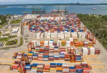 Containers empilhados em porto movimentado, simbolizando o crescimento das exportações de Santa Catarina.