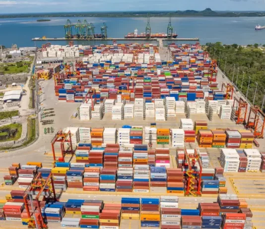 Containers empilhados em porto movimentado, simbolizando o crescimento das exportações de Santa Catarina.