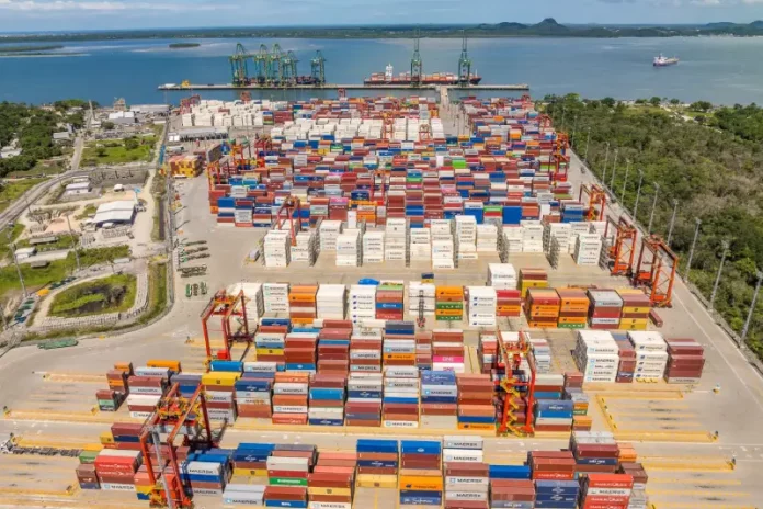 Containers empilhados em porto movimentado, simbolizando o crescimento das exportações de Santa Catarina.