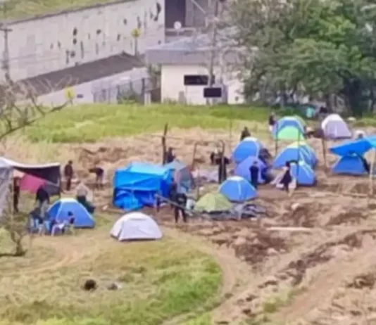 Grupo de pessoas monta barracas nos terrenos da União durante invasão no bairro Bela Vista, em São José.
